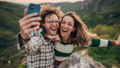 2 people taking a happy selfie outdoors