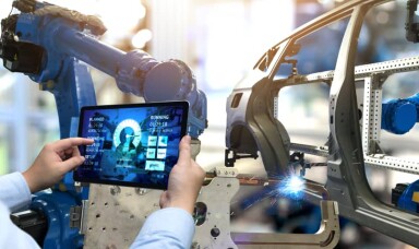 Worker in a car factory looking at a tablet
