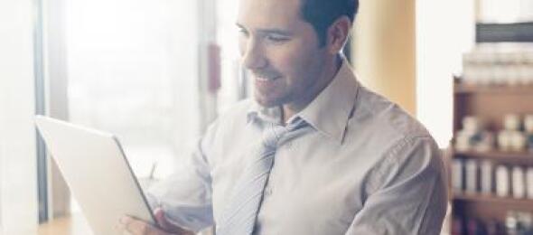 Man looking at a tablet at a cafe