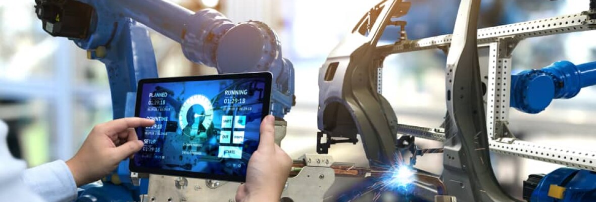 Worker in a car factory looking at a tablet