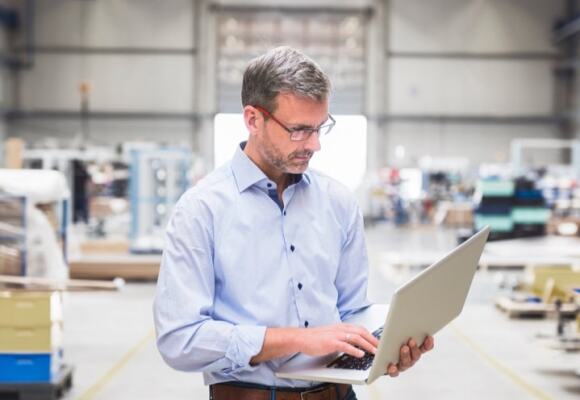 Man looking at a laptop in a warehouse