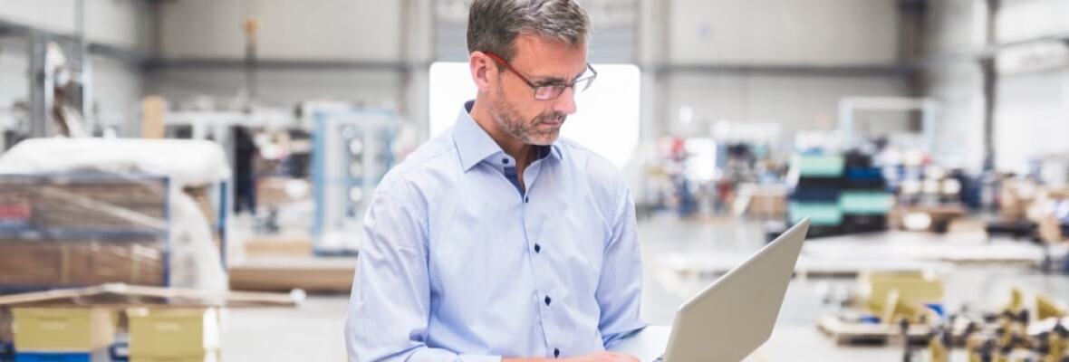 Man looking at a laptop in a warehouse