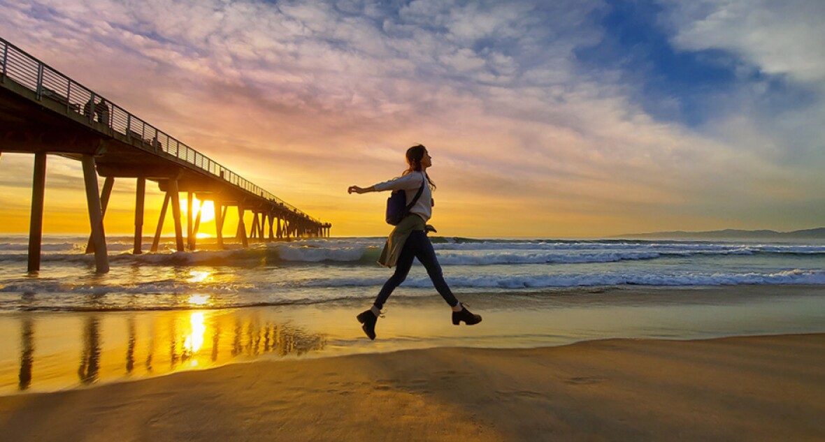 Person on a beach with sunset in the background