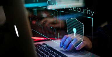 Person working on a laptop showing cyber security logo