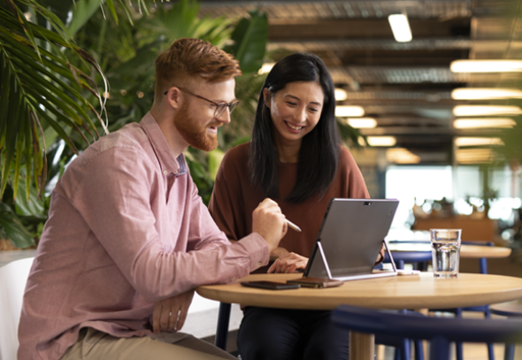 Man and woman working on a tablet in an office