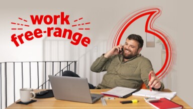 Work Free Range. Man using his laptop and talking on phone in his home office.
