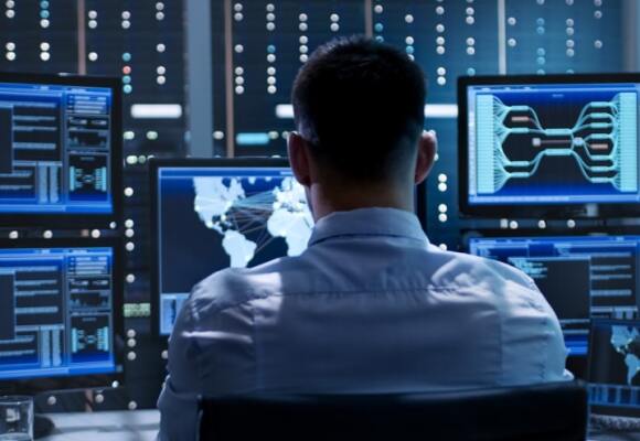 Man looking at multiple computer screens