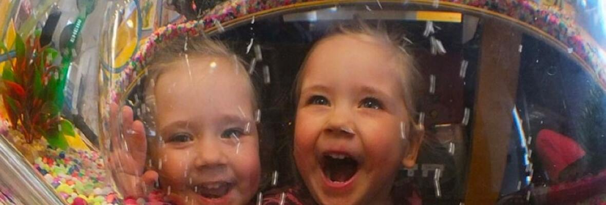 Two kids looking happy in front of a candy store