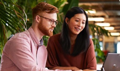 Man and woman looking at a laptop in an office