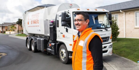 Waste Management worker in front of the work truck