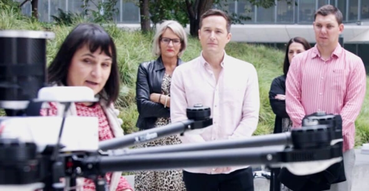 People looking at a drone
