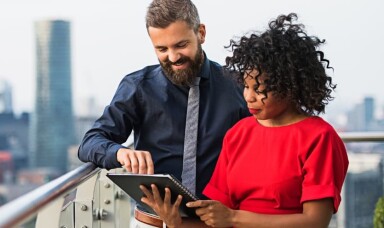 A man and a woman looking at a tablet