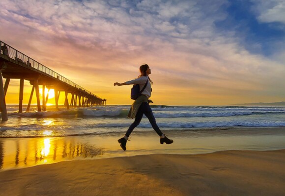 Person on a beach with sunset in the background