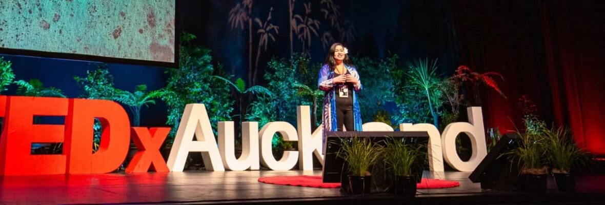 A woman onstage speaking at TEDxAuckland tūmanako