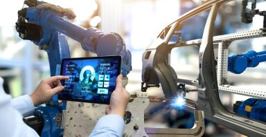 Worker in a car factory looking at a tablet