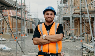Man in a construction site looking towards camera and smiling