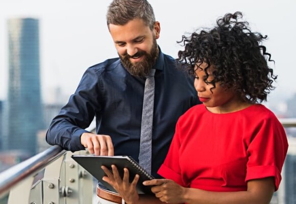 A man and a woman looking at a tablet