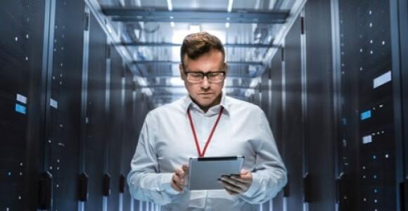 Man looking at a tablet in a server room