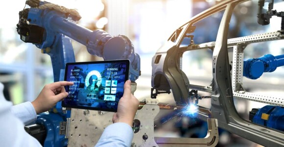 Worker in a car factory looking at a tablet