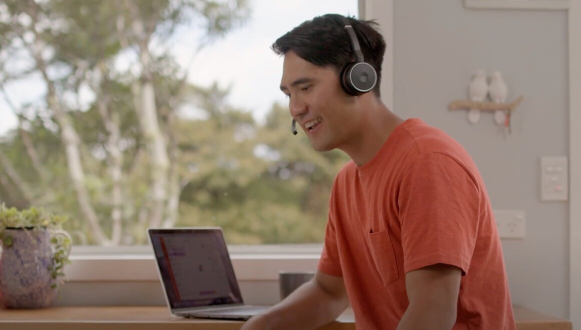 Man working on his laptop wearing headset