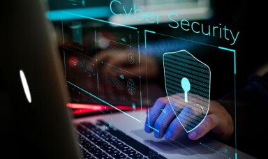Person working on a laptop showing cyber security logo