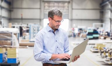 Man looking at a laptop in a warehouse