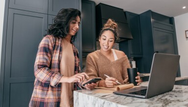 Woman showing her mobile phone to another woman