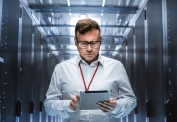 Man looking at a tablet in a server room