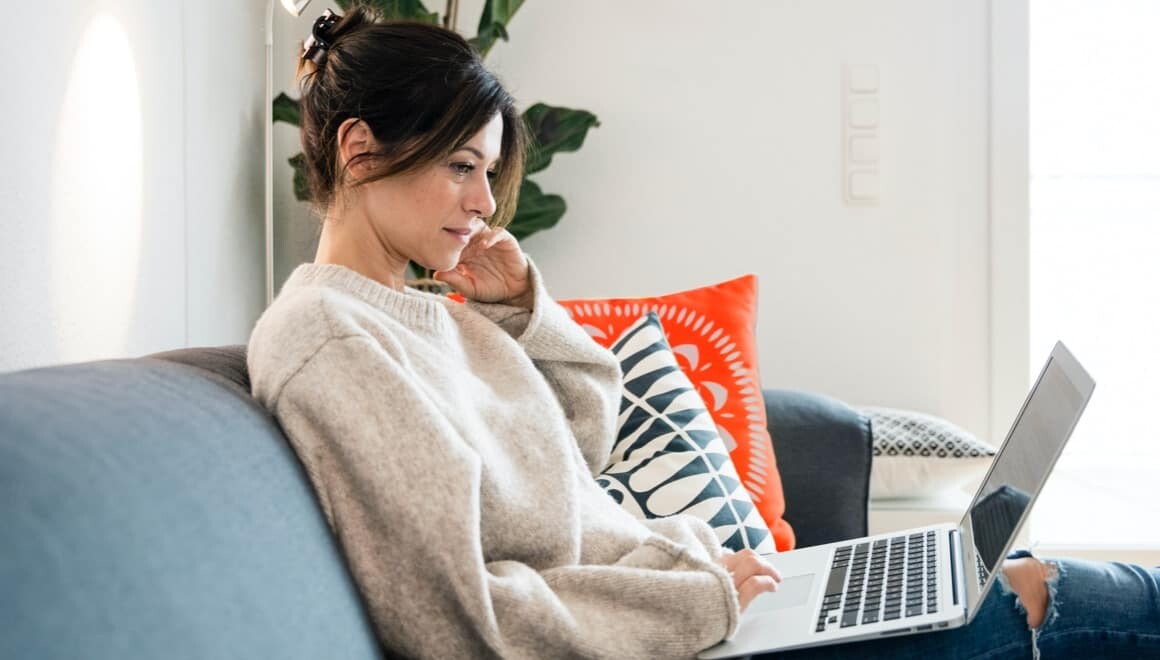 Lady sitting on couch and using laptop