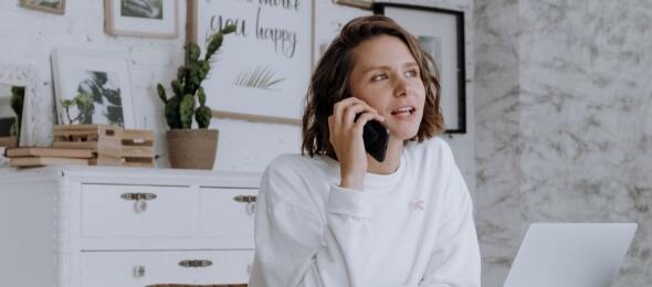 woman at her home office on her phone