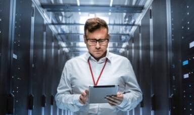 Man looking at a tablet in a server room