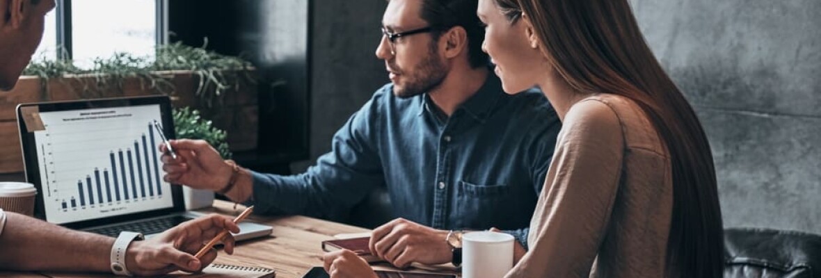 Man and woman looking at a graph on a monitor