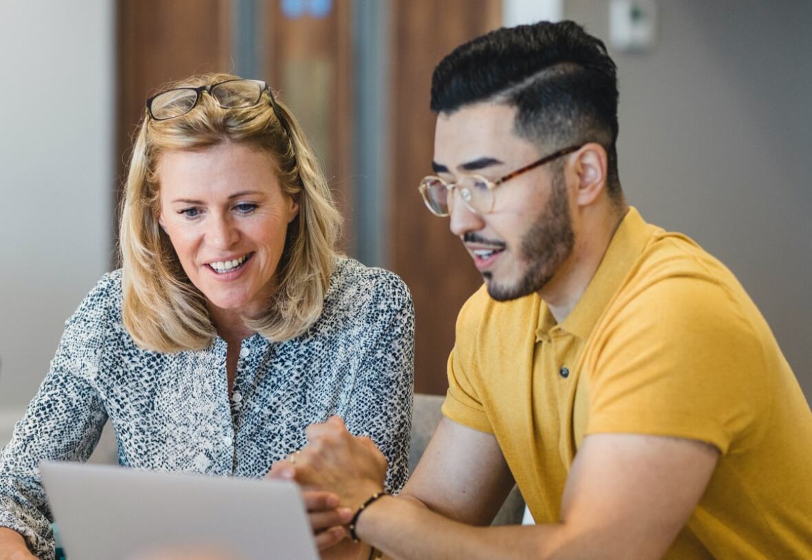 image of 2 people looking at a laptop