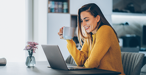 lady working on a laptop drinking coffee