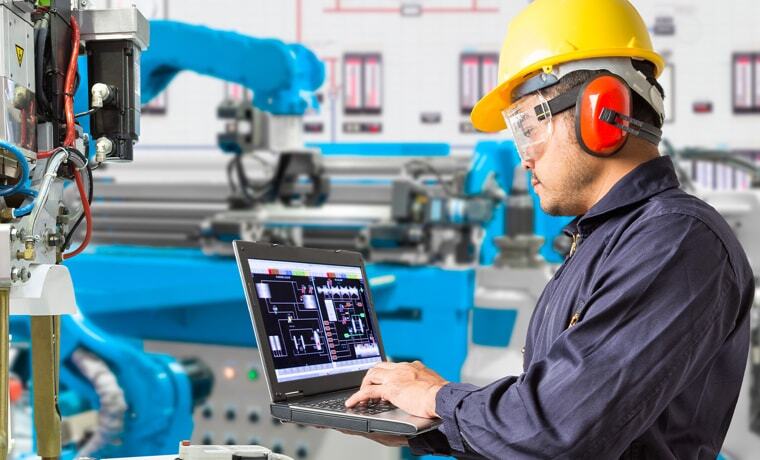 Man working on a laptop at a factory