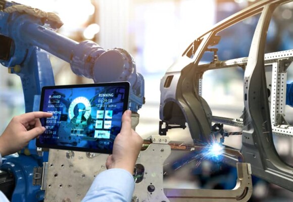 Worker in a car factory looking at a tablet