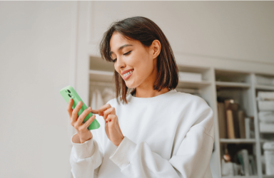 A smiling woman using her eSIM capable phone. 