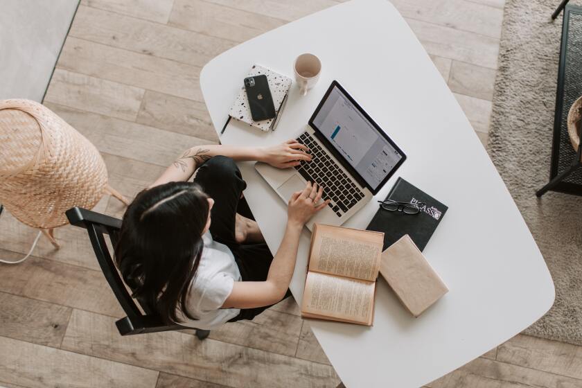 An overhead view of a girl studying with her laptop.